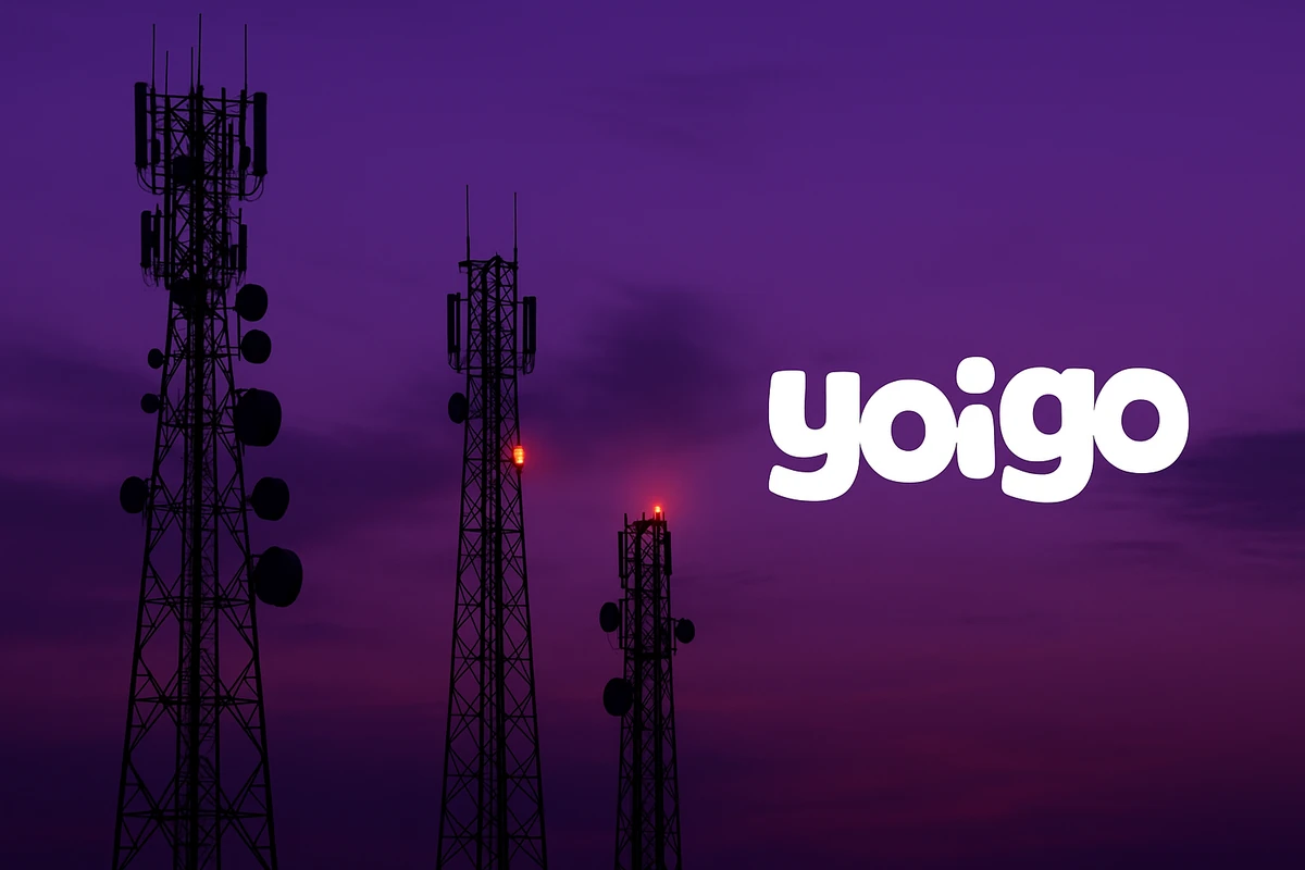 Antenas de telecomunicaciones apagándose al atardecer con el logotipo de Yoigo en primer plano.